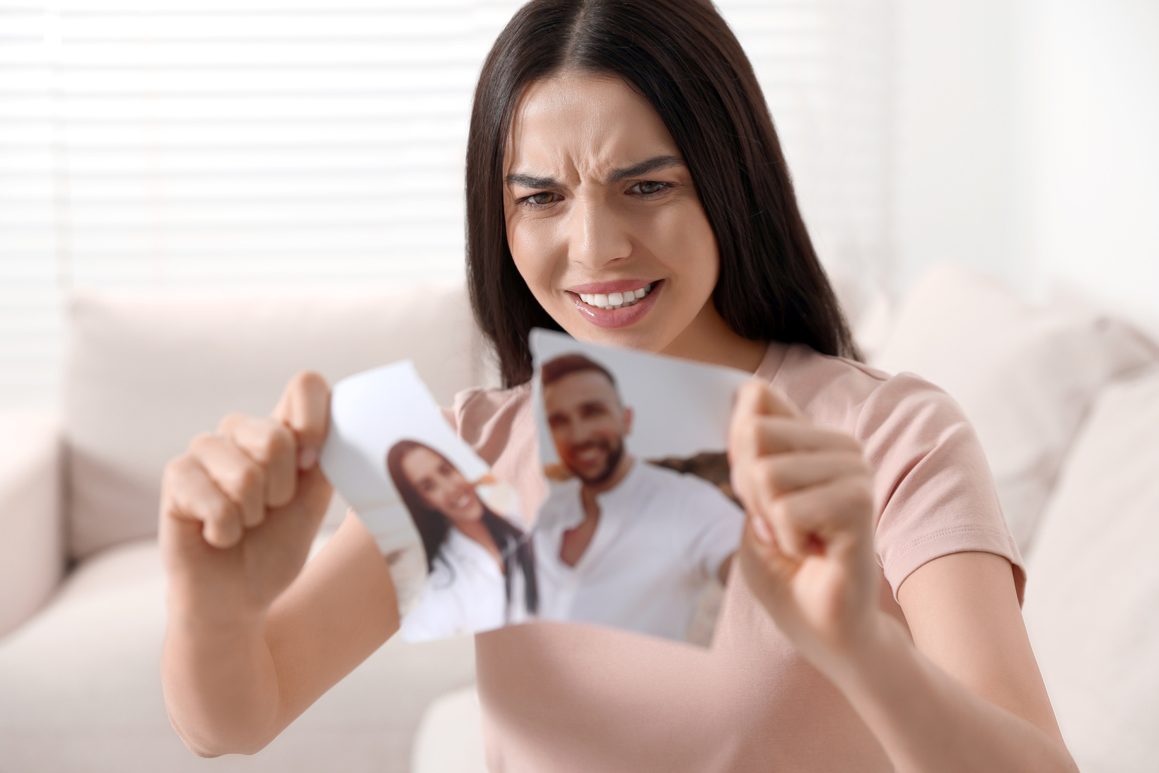 Upset Woman Ripping Photo at Home. Divorce Concept